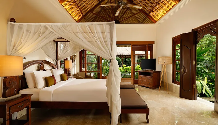 Elegant pavilion bedroom featuring a four-poster bed, vaulted thatched ceiling, and dark wood furniture near the garden at Villa Ohm