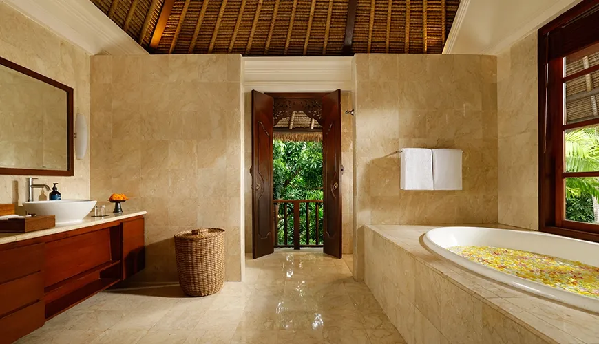 Luxurious master bathroom in a villa with marble stone walls, bathtub, and view of the tropical jungle at Villa Ohm
