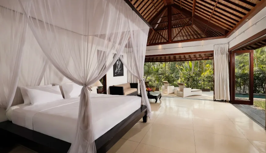 Canopy bed in luxurious Balinese bedroom with pool access at Villa Omecure