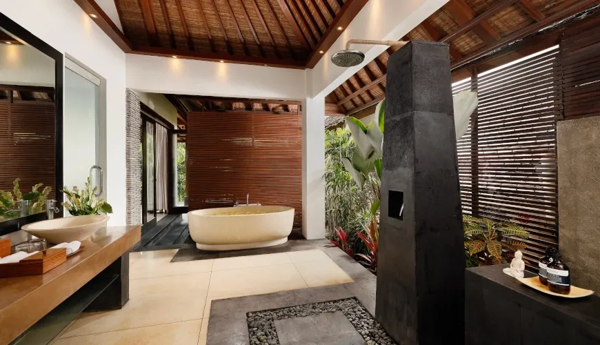 Exotic indoor outdoor bali bathroom with luxurious stone bathtub at Villa Omecure
