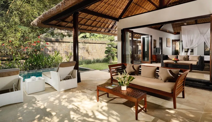 Resort bedroom with open doors leading to a private pool and patio at Villa Omecure