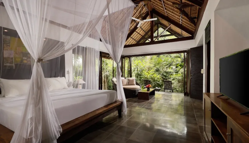 Serene Balinese bedroom with a canopy bed and jungle view at Villa Omecure