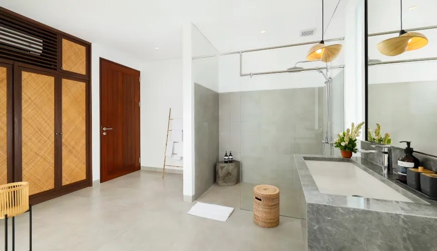 Luxurious modern bathroom with stone vanity and glass walk-in shower at Villa Omekali