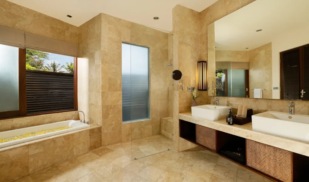 Marble-tiled bathroom with dual sinks and a sunken bathtub at Villa Oshra