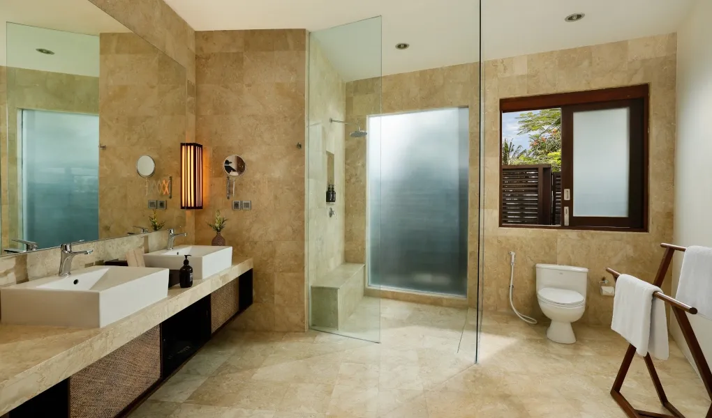 Modern stone bathroom with a walk-in shower and dual vanities at Villa Oshra