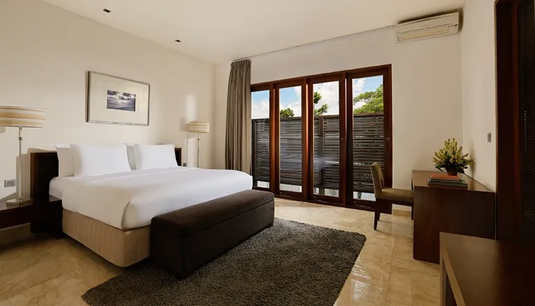 Serene villa bedroom featuring large bed desk and outdoor views at Villa Oshra