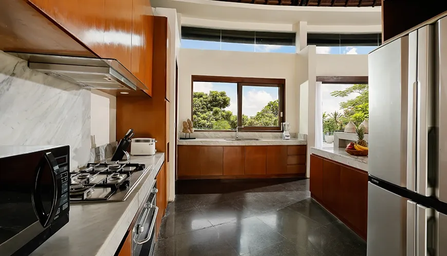 Sleek kitchen with wooden cabinets marble counters and modern appliances at Villa Oshra