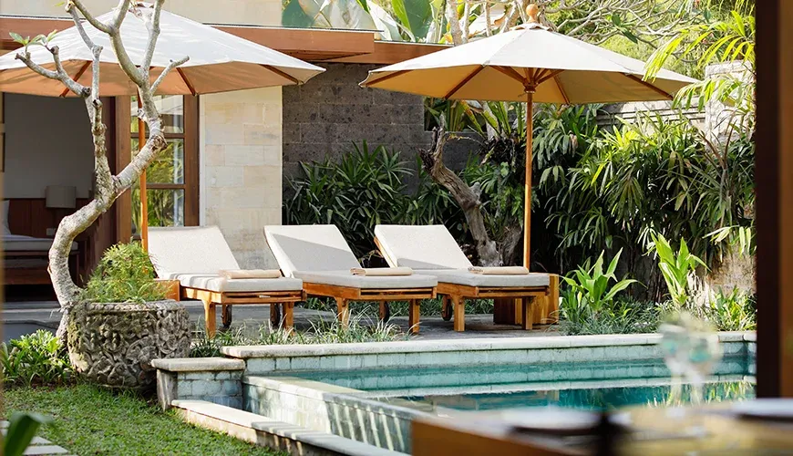 Relaxing sun loungers by a pool in a tropical garden at Villa Perere9
