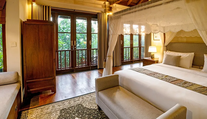 Beautiful villa bedroom with a four-poster bed, a large balcony, and high wooden ceilings at Villa Pulung Jimbaran