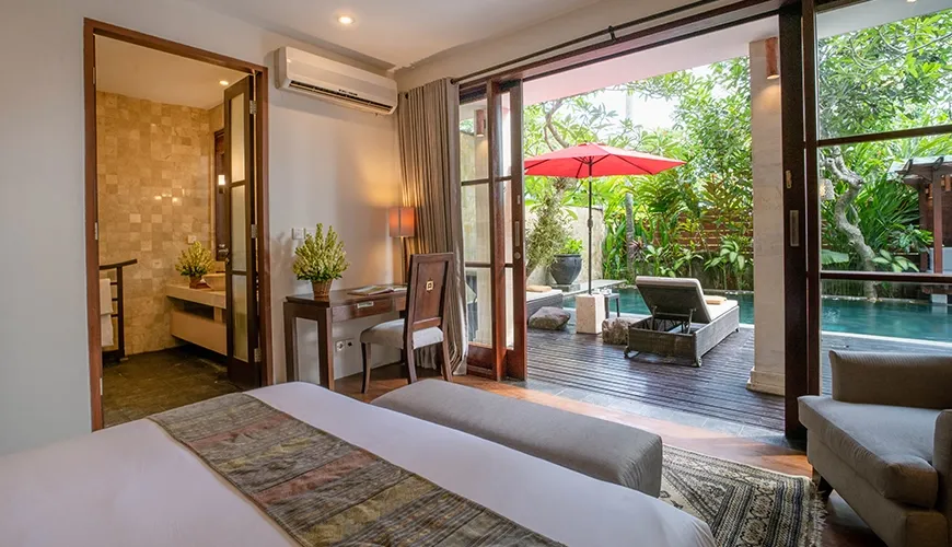 Beautiful villa bedroom with a private patio, a swimming pool, and an outdoor lounge area at Villa Pulung Jimbaran
