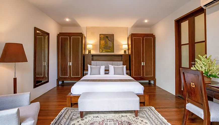 Comfortable villa bedroom featuring a large bed and two matching wooden wardrobes at Villa Pulung Jimbaran