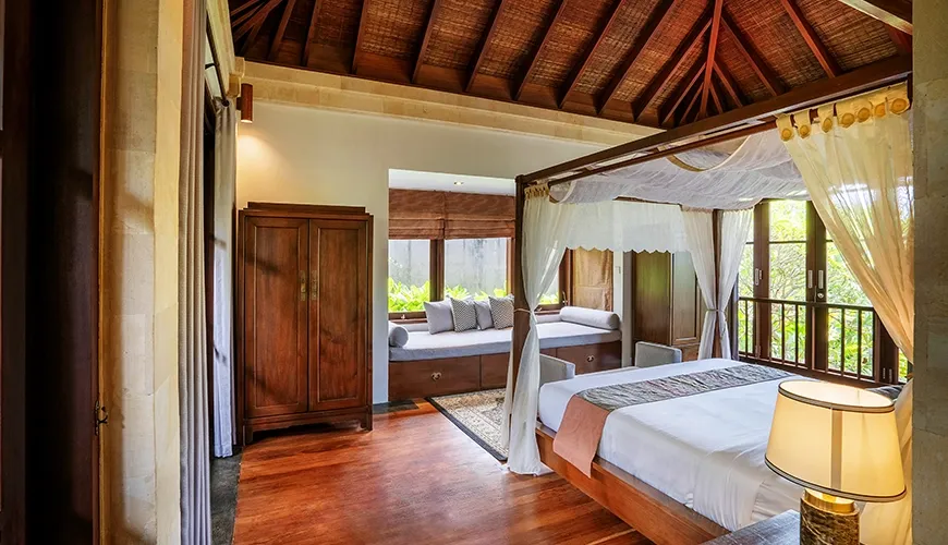 Cozy and inviting villa bedroom with a classic four-poster bed and a daybed by the window at Villa Pulung Jimbaran