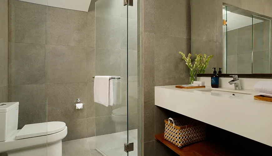 Bright modern bathroom featuring a walk-in shower with glass doors and a spacious double vanity at Villa Santos Cliff View