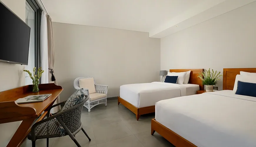 Bright twin bedroom featuring two beds with a small desk and comfortable armchairs at Villa Santos Cliff View