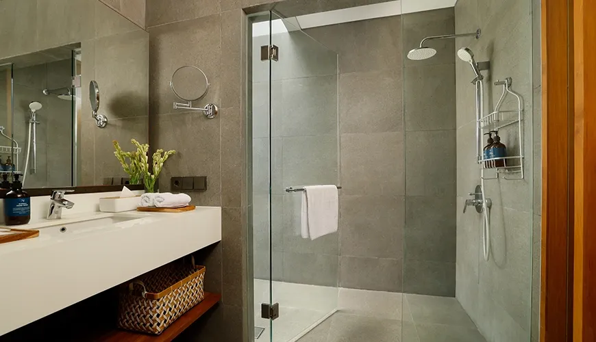 Spacious modern bathroom featuring a large glass walk-in shower with dual shower heads and sleek gray tiling at Villa Santos Cliff View