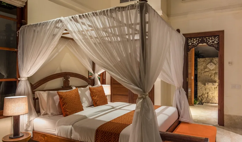 Balinese bedroom with elegant canopy bed at night at Villa Senada