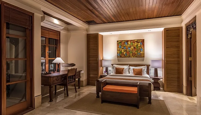 Bedroom with canopy bed desk and vibrant artwork at Villa Senada