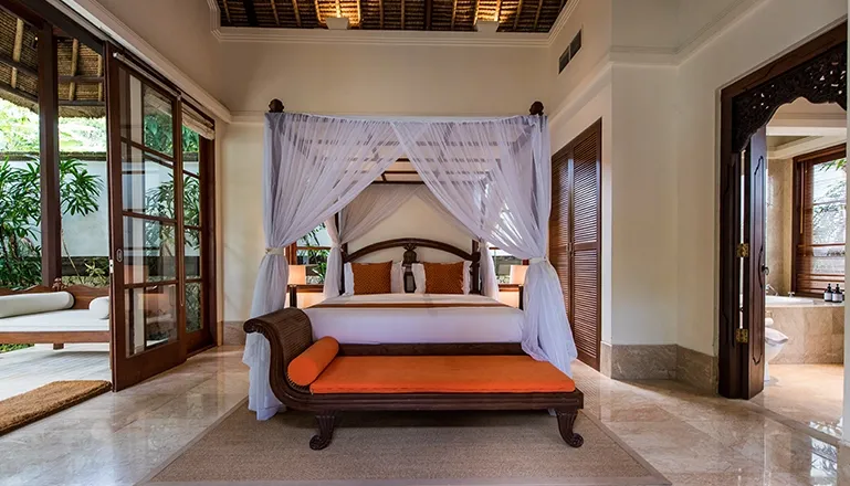 Inviting bedroom with canopy bed connecting to bathroom and patio at Villa Senada