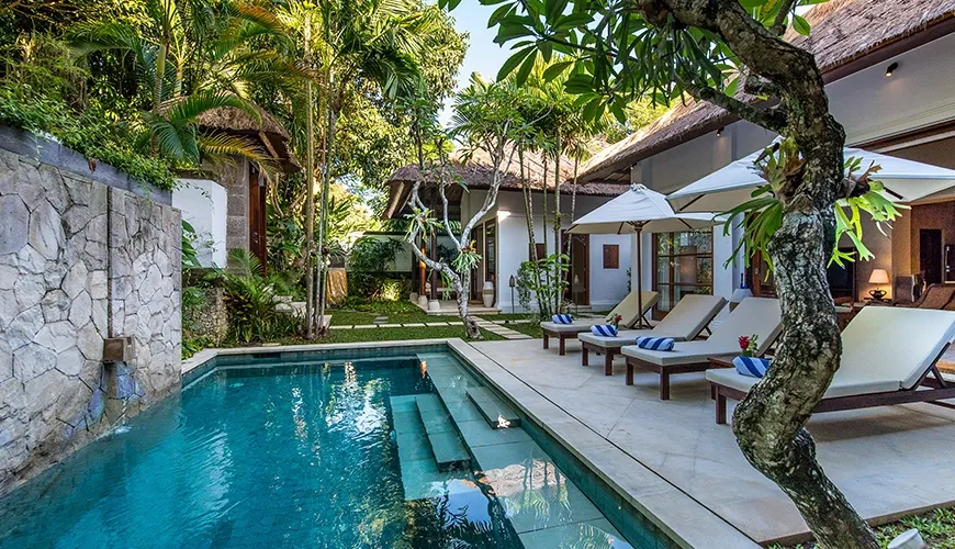 Swimming pool with loungers and waterfall feature by villa at Villa Senada