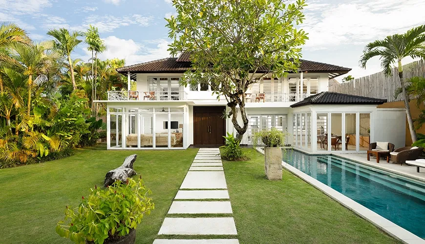 Grand white villa exterior long swimming pool serene landscaped garden at Villa Swarna