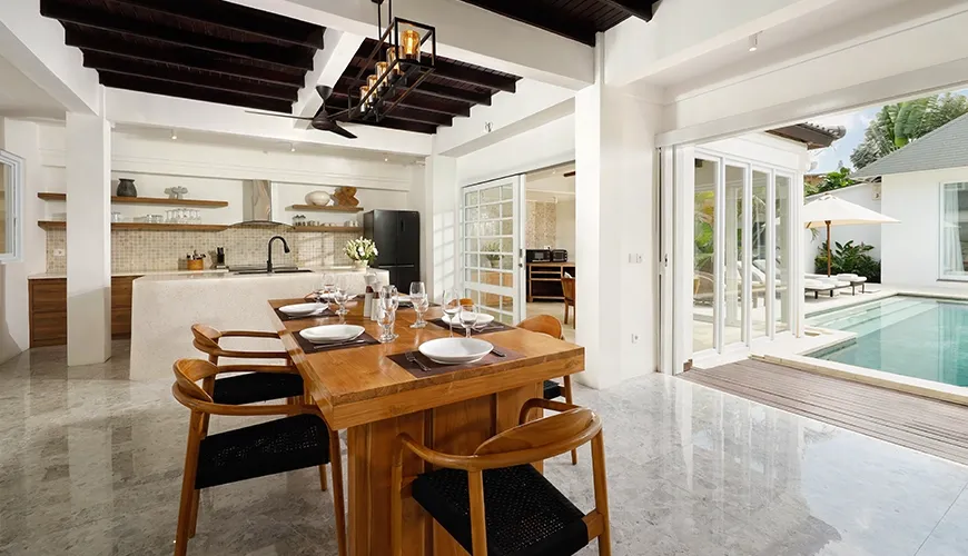 Inviting indoor dining space with a stylish kitchen connected to a beautiful outdoor swimming pool patio at Villa Swarna