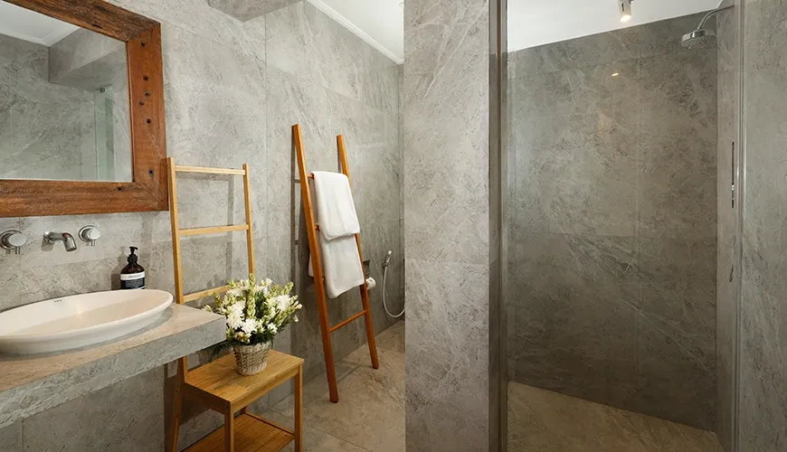 Luxurious bathroom interior with a contemporary vanity, natural wood accents, and clean minimalist design elements at Villa Swarna