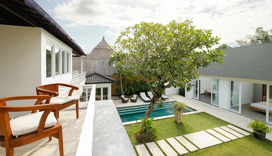 Luxurious villa balcony view showcasing a private courtyard with a refreshing swimming pool and a manicured garden at Villa Swarna