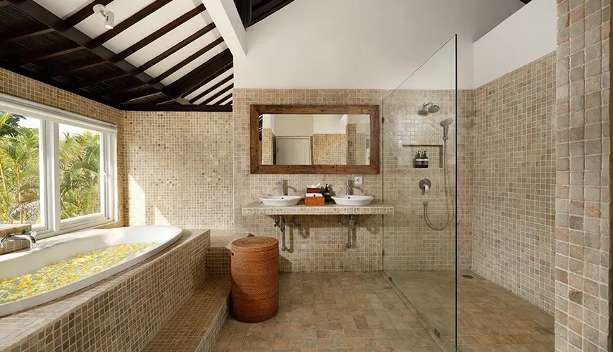 Luxury bathroom bathtub double vanity glass shower tiled walls at Villa Swarna