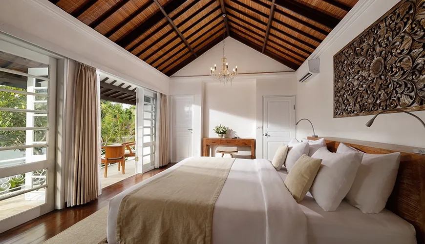 Master bedroom king bed balcony ornate artwork thatched ceiling at Villa Swarna