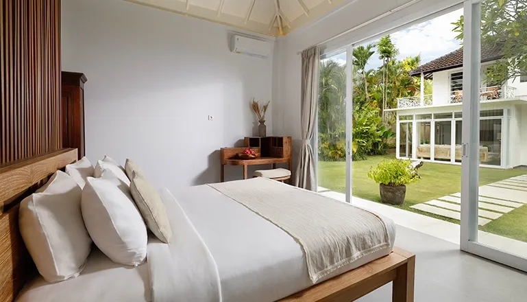 Modern bedroom king bed overlooking lush tropical garden scenery at Villa Swarna