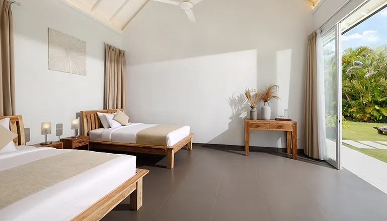 Spacious bedroom two beds outdoor garden tropical plants view at Villa Swarna