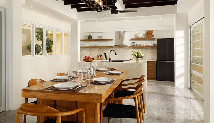 Well-appointed kitchen dining wooden table island features modern appliances at Villa Swarna