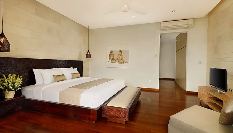 Modern bedroom king bed TV artwork wooden floor at Villa Tenang