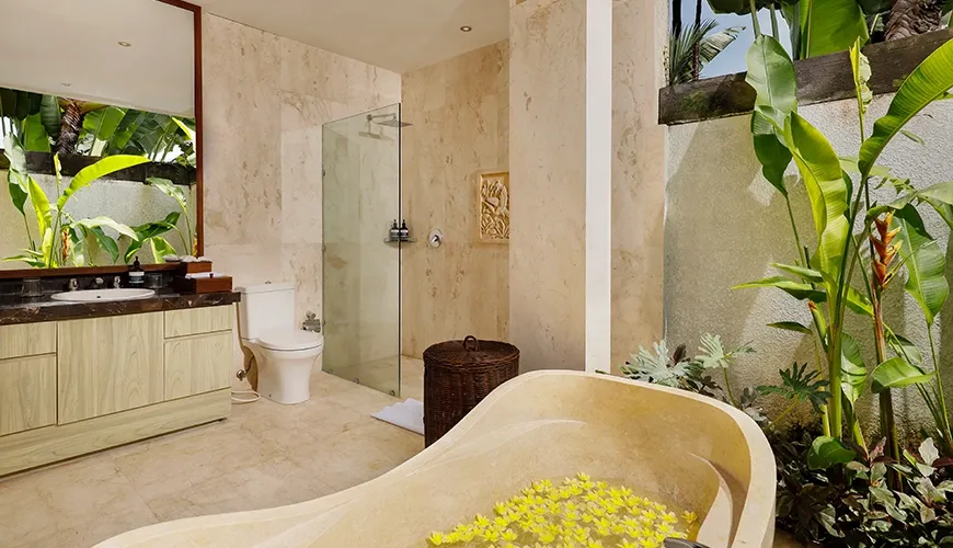 Stone bathtub floral accents tropical garden bathroom at Villa Tenang