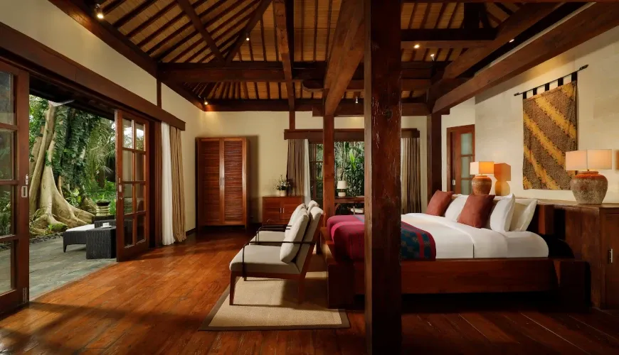 Spacious bedroom with twin beds, wooden beams, and a private patio at Villa Tirtadari