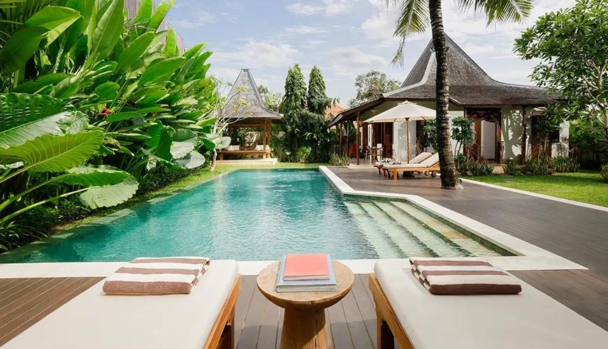 Beautiful outdoor pool area of a villa surrounded by lush tropical plants and traditional pavilion architecture at Villa Tropical Svasti