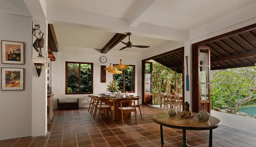 Bright villa dining space with natural light flowing onto the large wooden table and terracotta floor tiles at Villa Tropical Svasti