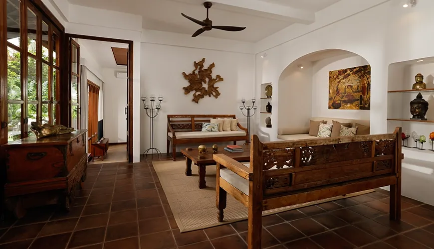 Comfortable villa living room featuring unique carved wooden furniture and beautiful traditional decorative artwork at Villa Tropical Svasti