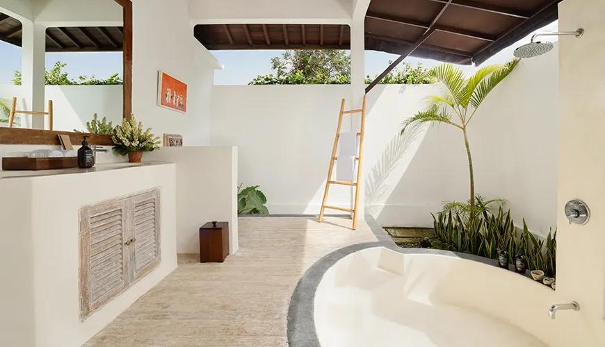 Elegant master bathroom with a white stone vanity and integrated bathtub under a tropical pavilion at Villa Tropical Svasti
