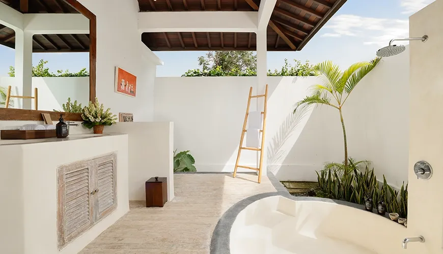 Open-air villa bathroom featuring a spacious outdoor soaking tub and exposed wood ceiling with a shower at Villa Tropical Svasti