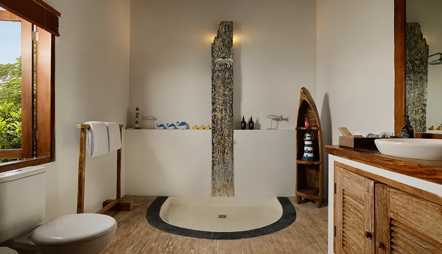 Rustic villa bathroom featuring a distinctive stone-clad shower natural wood vanity and nautical-themed decorations at Villa Tropical Svasti