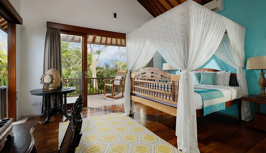 Beautiful master bedroom suite featuring a four poster canopy bed, vaulted wooden ceiling, and a private outdoor balcony at Villa Uma Nina