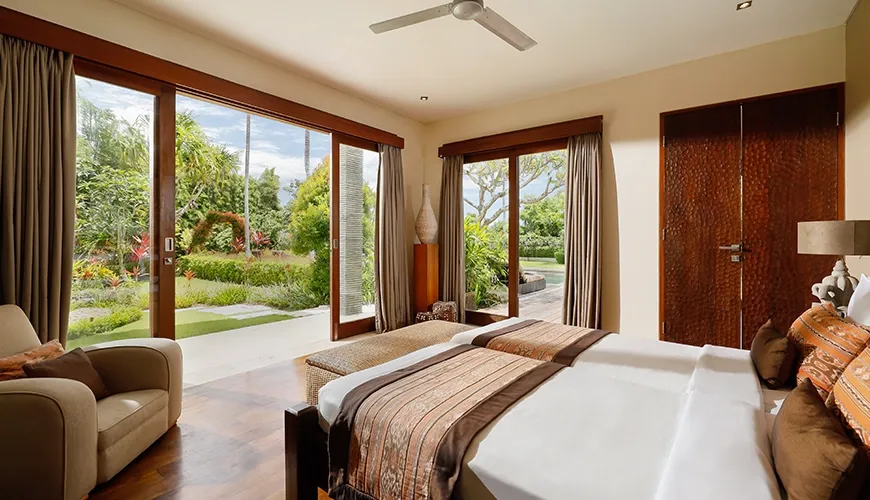 Beautiful villa bedroom with two beds, large sliding doors, and a serene garden view at Villa Uma Nina