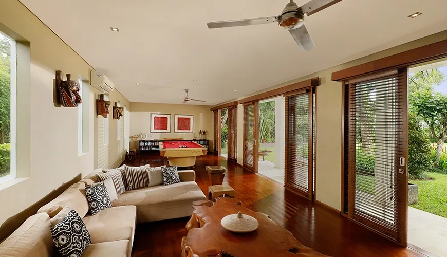 Bright villa living area with wooden floors, comfortable couches, and a full-size billiards table at Villa Uma Nina
