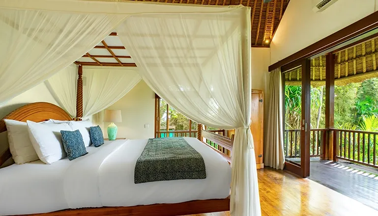 Luxurious and airy villa bedroom with a classic four-poster canopy bed and a private balcony at Villa Uma Nina
