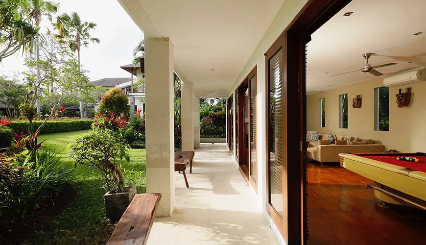 Spacious outdoor hallway with wooden bench and large sliding glass doors leading to the living area at Villa Uma Nina