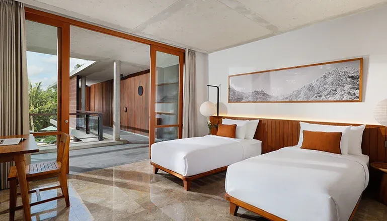 Bright bedroom with twin beds and outdoor patio access at Villa Uma Santai