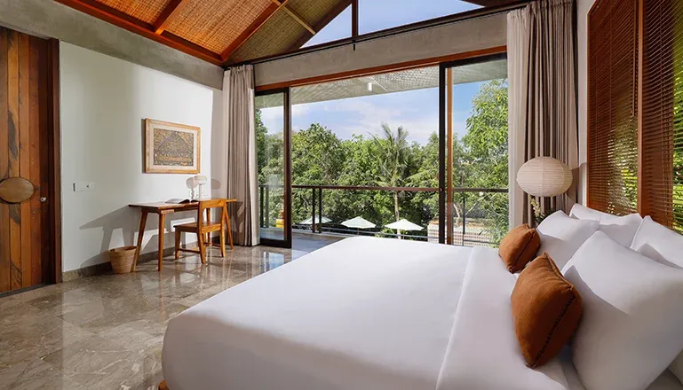 Elegant bedroom with a view of lush greenery at Villa Uma Santai
