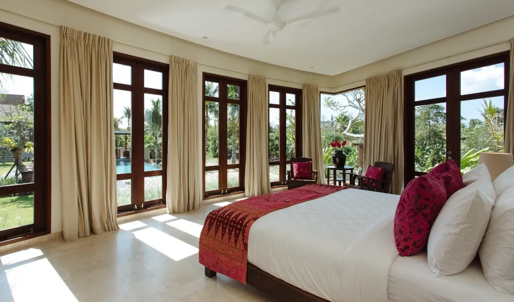 Beautiful guest bedroom with fuschia bedding and floor-to-ceiling windows at Villa Umah Daun