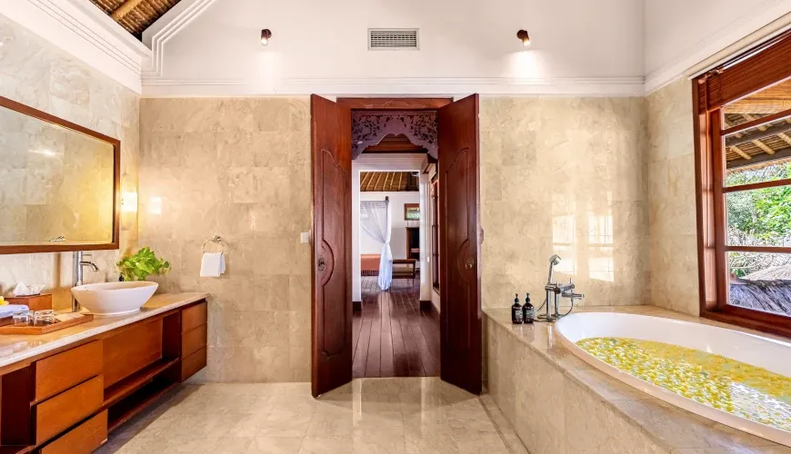Modern Balinese bathroom with beautiful carved wood at Villa Umarya